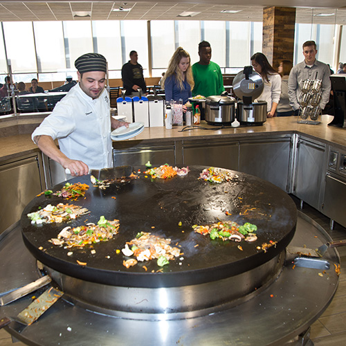 Chef cooking on grill in Superior Dining