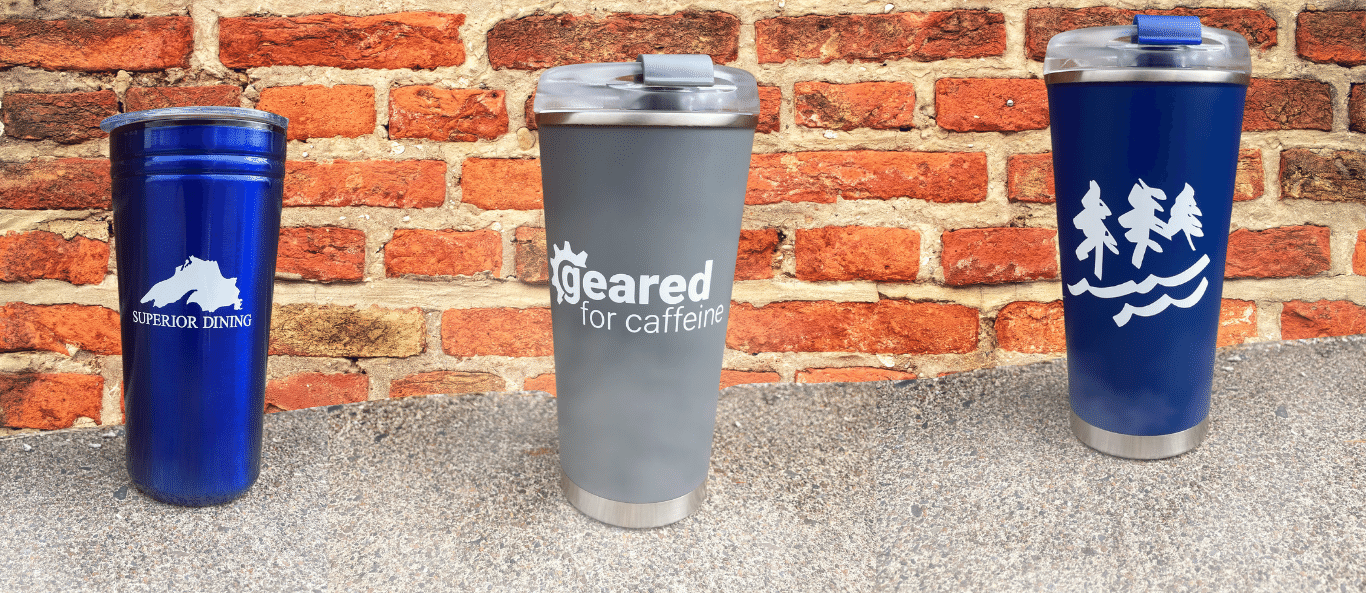Reusable Mugs in front of brick wall